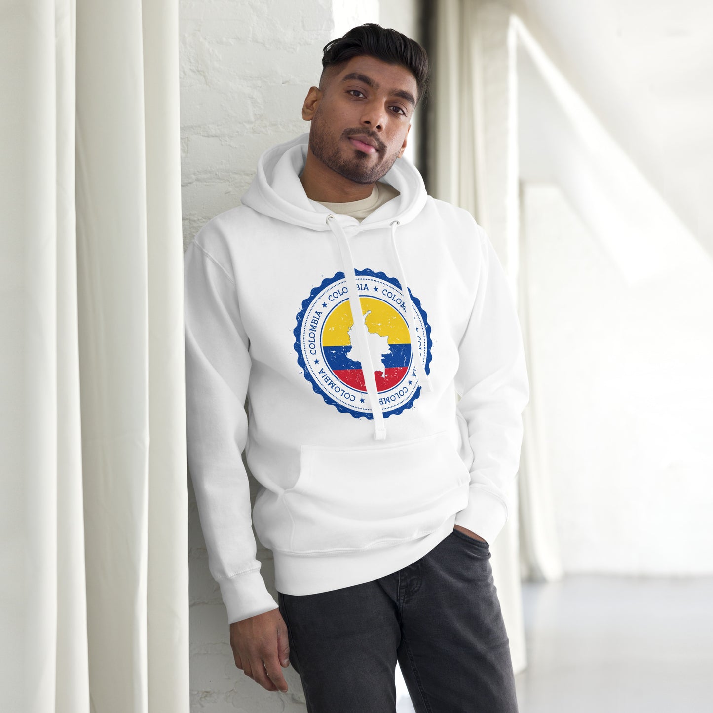 Unisex white hoodie featuring a circular Colombian heritage design with vibrant yellow, blue, and red accents, perfect for showcasing cultural pride and style.