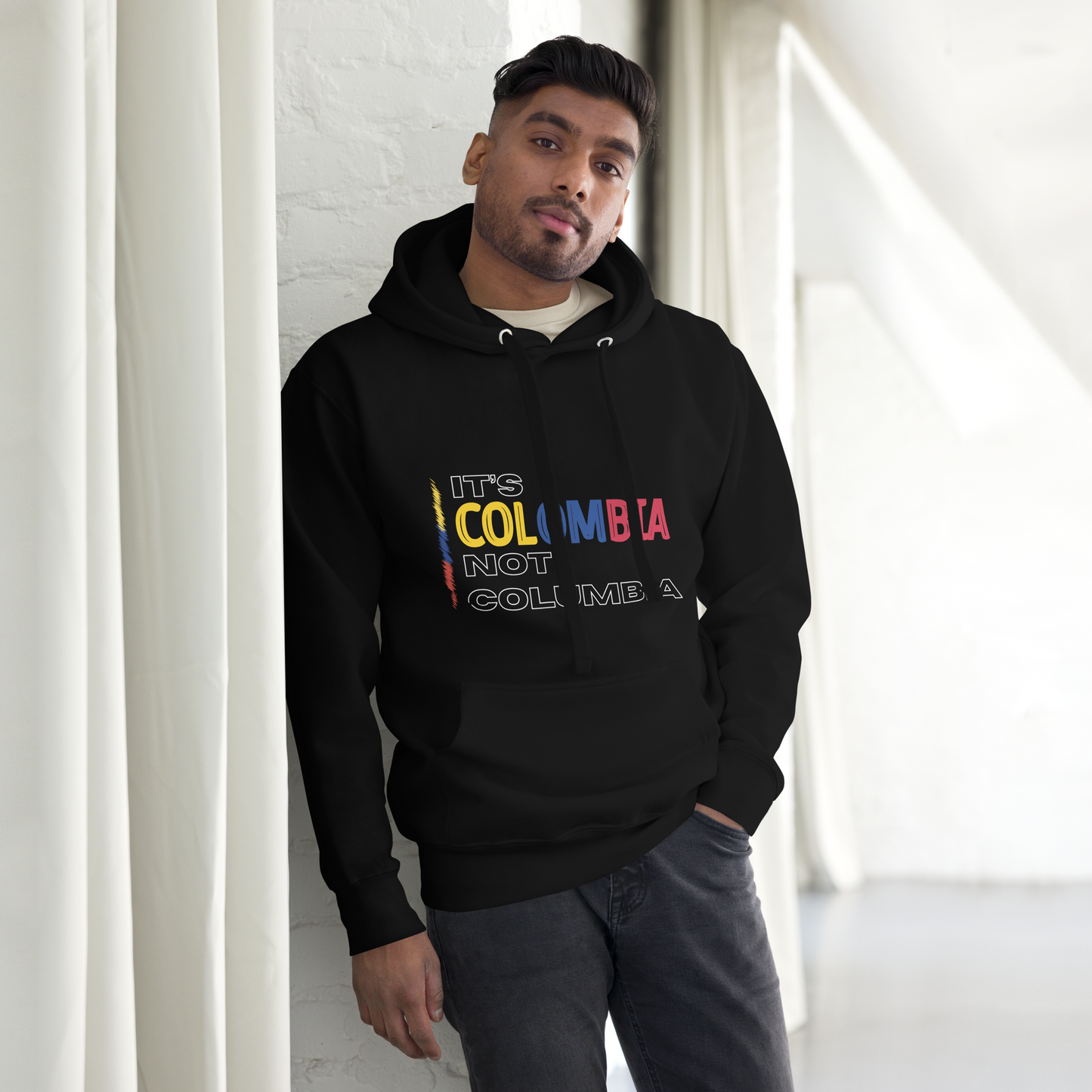 Unisex Black premium hoodie featuring the bold statement 'It's Colombia, Not Columbia,' emphasizing Colombian pride and identity. The design is a strong visual representation of cultural authenticity
