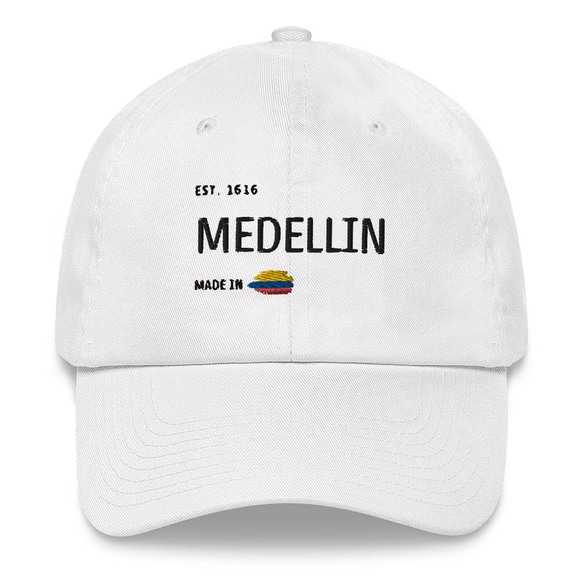 White dad hat featuring 'Medellín - Made in Colombia' embroidery with a small Colombian flag. A stylish and minimal way to represent your city with pride.