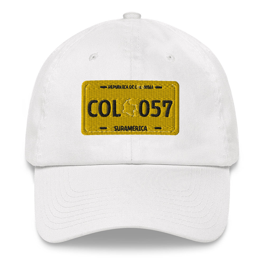 Classic white dad hat featuring a vintage yellow Colombian license plate design with 'COL 057 Suramérica' text. A stylish way to represent Colombian culture with a retro touch.