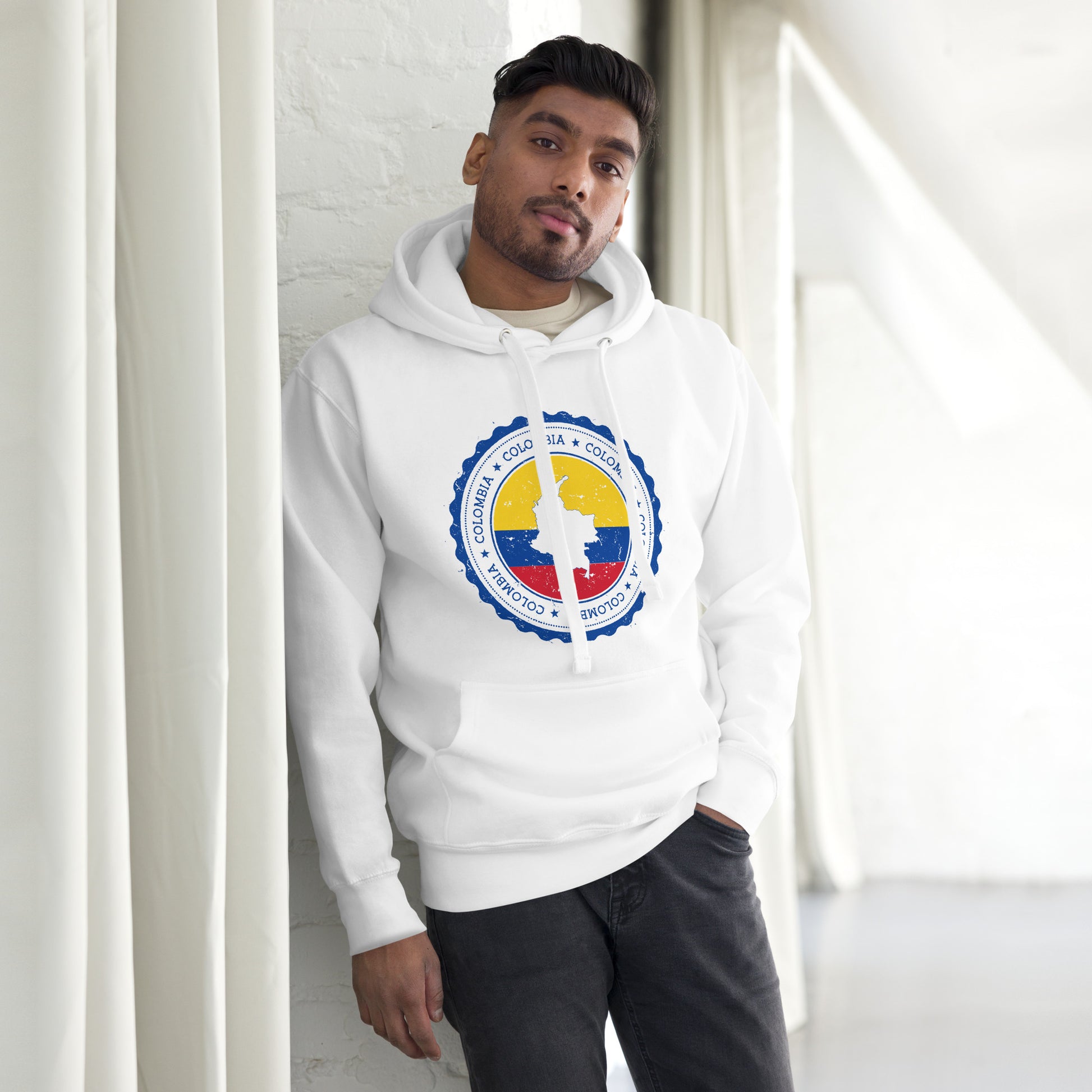 Unisex white hoodie featuring a circular Colombian heritage design with vibrant yellow, blue, and red accents, perfect for showcasing cultural pride and style.