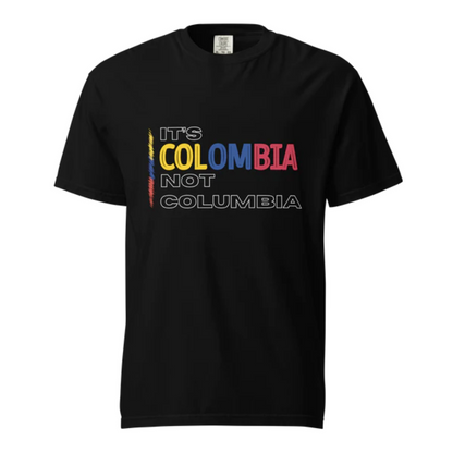 Black t-shirt featuring the bold phrase 'It's Colombia, Not Columbia' in the colors of the Colombian flag. A must-have for anyone proud of their heritage and tired of the common misspelling.