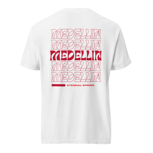 White T-shirt featuring a bold Medellin design in red with repeated text and 'Eternal Spring' written at the bottom, celebrating the city's nickname.